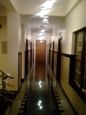 an empty hallway of a building with a long corridor at Hotel Lovely Nest in Coimbatore