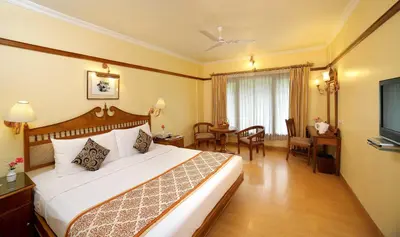 a hotel room with a large bed and a table at The Raviz Kadavu, Kozhikode in Kozhikode