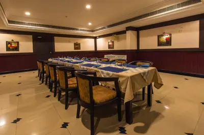 a long dining room with a long table and chairs at Kallada Regency in Irinjālakuda