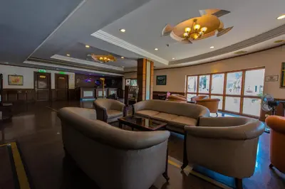 a lobby with couches and chairs in a building at Kallada Regency in Irinjālakuda