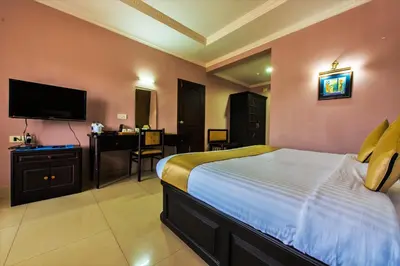 a bedroom with a bed and a flat screen tv at Kallada Regency in Irinjālakuda