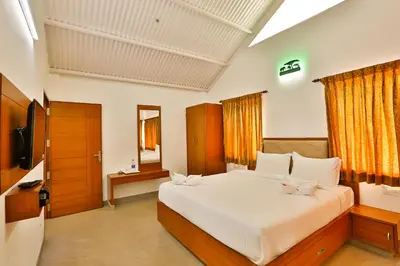 a bedroom with a large white bed and a television at Mystique stay resort in Kotagiri