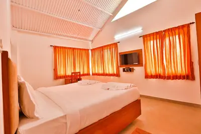 a bedroom with a large bed and two windows at Mystique stay resort in Kotagiri