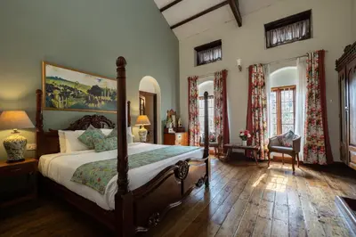 a bedroom with a large bed with a wooden floor at King's Cliff in Ooty