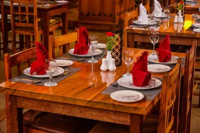 a wooden table with red napkins and glasses on it at Destiny - The Farm Resort in Ooty