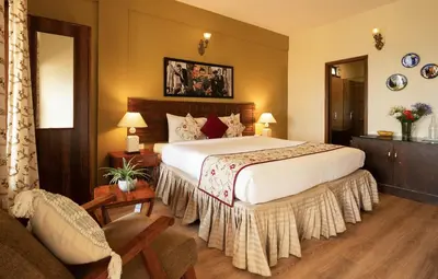 a hotel room with a large bed and a couch at Sherlock in Ooty