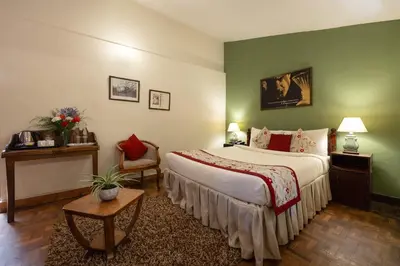a bedroom with a large bed and a green wall at Sherlock in Ooty