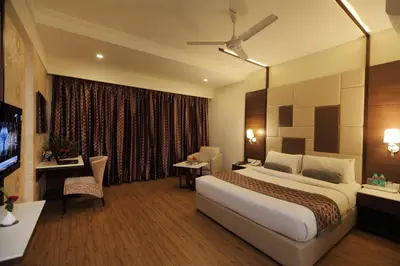 a hotel room with a large bed and a desk at Hotel Pai Vista in Mysore
