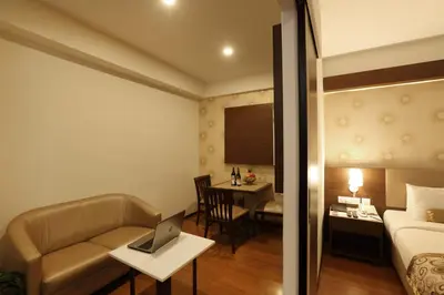 a hotel room with a bed and a laptop on a table at Hotel Pai Vista in Mysore