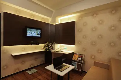 a room with a tv and a laptop on a table at Hotel Pai Vista in Mysore