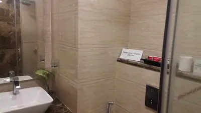 a bathroom with a sink and a sign on a wall at Hotel Pai Vista in Mysore