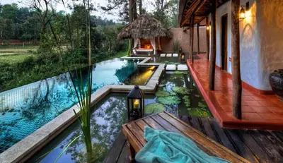 a swimming pool with a house at Evolve Back Coorg in Siddapur