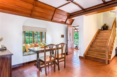 a dining room with a table and wooden ceilings at Evolve Back Coorg in Siddapur