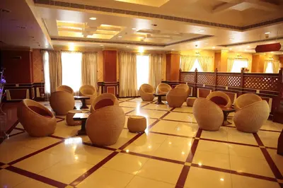 a large room with chairs and tables on a tiled floor at Joys Palace Hotel in Trichūr
