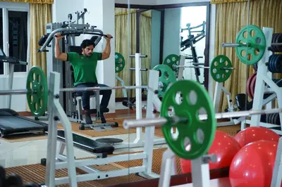 a man in a gym with a simulator at Joys Palace Hotel in Trichūr
