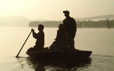 a group of three people on a boat on the water at Evolve Back Kabini in Begūr