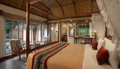 a bedroom with a large bed in a room at Evolve Back Kabini in Begūr