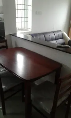 a living room with a table and a couch at Neo Nirmal Residency in Ooty