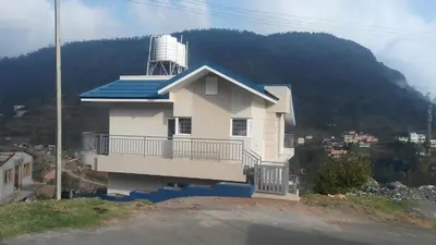 a house on top of a hill with a water tower at Neo Nirmal Residency in Ooty