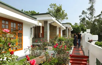 a group of people walking in front of a house at Elysium Garden in Munnar