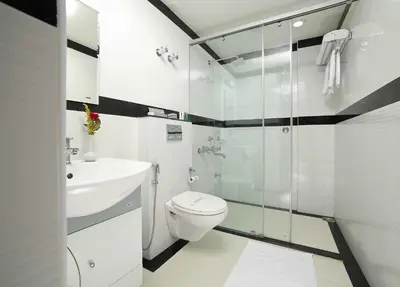 a bathroom with a toilet and a glass shower at Elysium Garden in Munnar