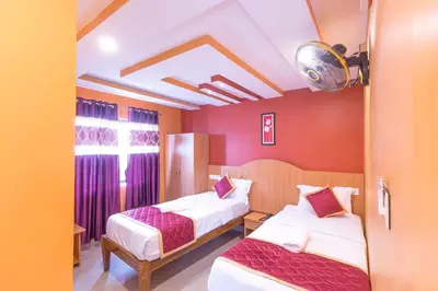 a hotel room with two beds and purple walls at Sree Comforts in Kushālnagar