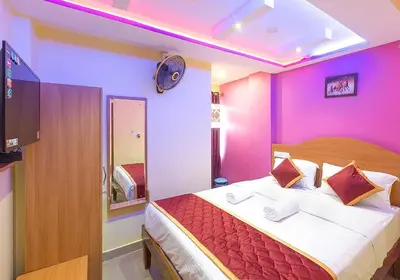 a bedroom with a large bed with purple walls at Sree Comforts in Kushālnagar