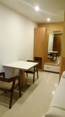 a living room with a table and a kitchen at Hotel Kapilavasthu in Palakkad