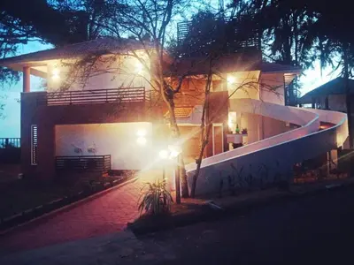 a house with lights on the side of it at night at Kappad Beach Resort in Kappad