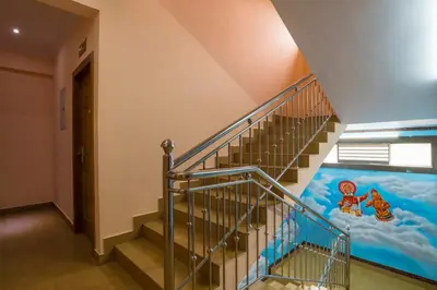 a staircase with a mural on the wall at Blue Bell Cochin Airport Hotel in Nedumbassery