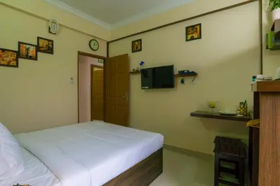a bedroom with a white bed and a television at Blue Bell Cochin Airport Hotel in Nedumbassery