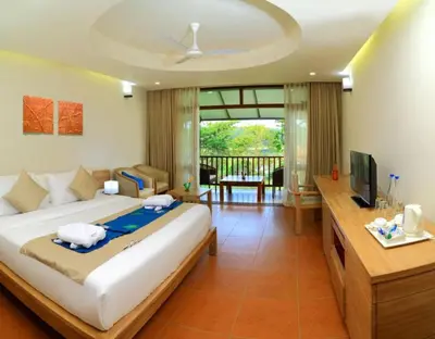 a bedroom with a large bed and a television at Whispering Waters in Malayāttūr