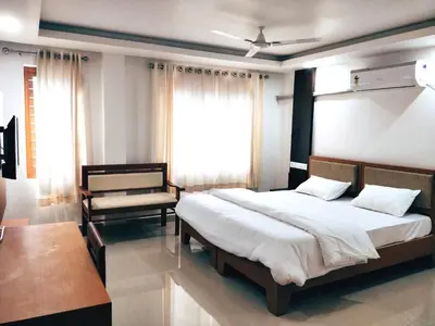 a bedroom with a large bed and a window at Prajapuri Hotel in Trichūr