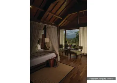 a bedroom with a bed and a room with a desk at The Serai Bandipur in Bandipūr