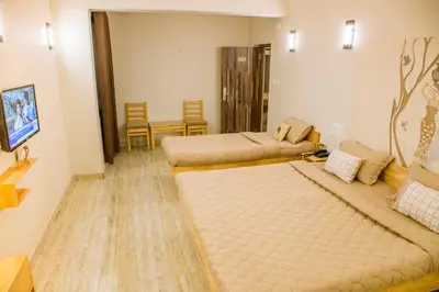 a room with two beds and a table and chairs at Rathna Square in Pollāchi