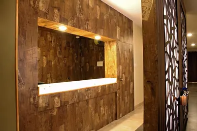 a wooden wall with a mirror in a hallway at Rathna Square in Pollāchi