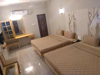 a small room with two beds and a mirror at Rathna Square in Pollāchi