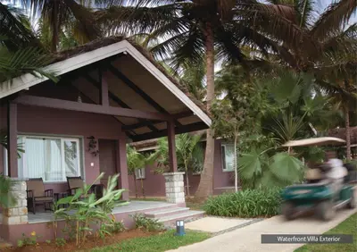 a person riding a scooter in front of a house at The Serai Kabini in Begūr