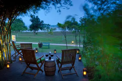 two chairs and a table with candles on a patio at The Serai Kabini in Begūr