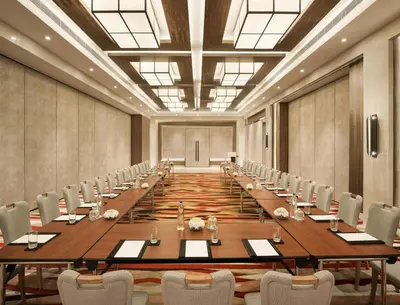 a large conference room with a long table and chairs at The Residency Towers Coimbatore in Coimbatore