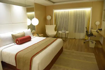 a bedroom with a large bed with a red bag on it at The Residency Towers Coimbatore in Coimbatore