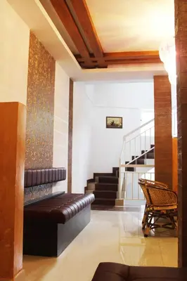 a living room with a couch and stairs at Landy Queen in Munnar