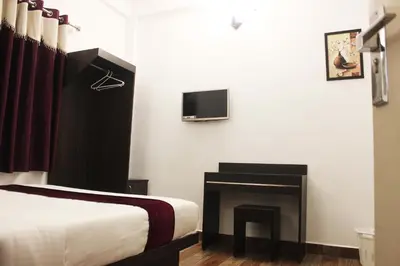 a bedroom with a bed and a fireplace and a tv at Landy Queen in Munnar