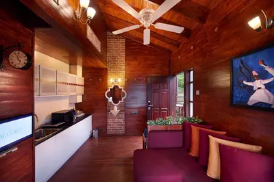 a living room with purple chairs and a clock on the wall at Accord Highland Hotel Ooty in Ooty