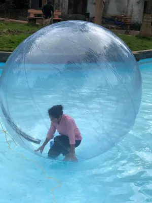 a child in a bubble ball in a pool at Sandalo Castle Resorts in Gūdalūr