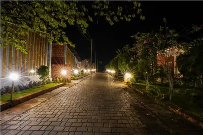 an empty street at night with street lights at Sixth Element in Kushālnagar