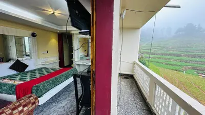 a room with a bed and a balcony with a view at Mountain View cottage in Ooty