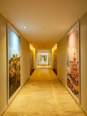 a hallway in a building with paintings on the walls at Hotel Divine Fort in Palani