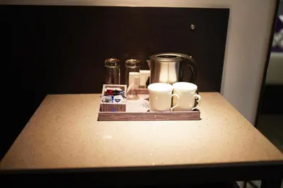 a table with cups and mugs on top of it at Regency Palani by GRT Hotels in Palani