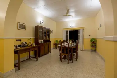 a kitchen and dining room with a table and chairs at Ama Plantation Trails Coorg in Gonikoppal